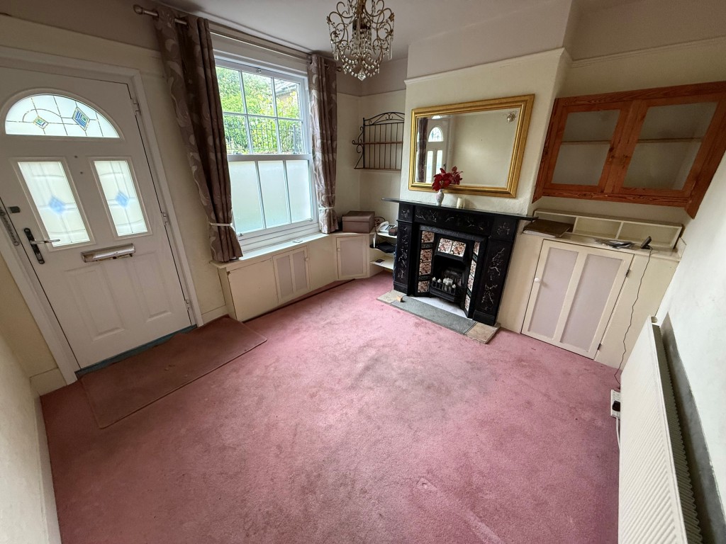 Lot: 76 - TWO-BEDROOM MID-TERRACE HOUSE FOR IMPROVEMENT - Living room showing window, fireplace and front door